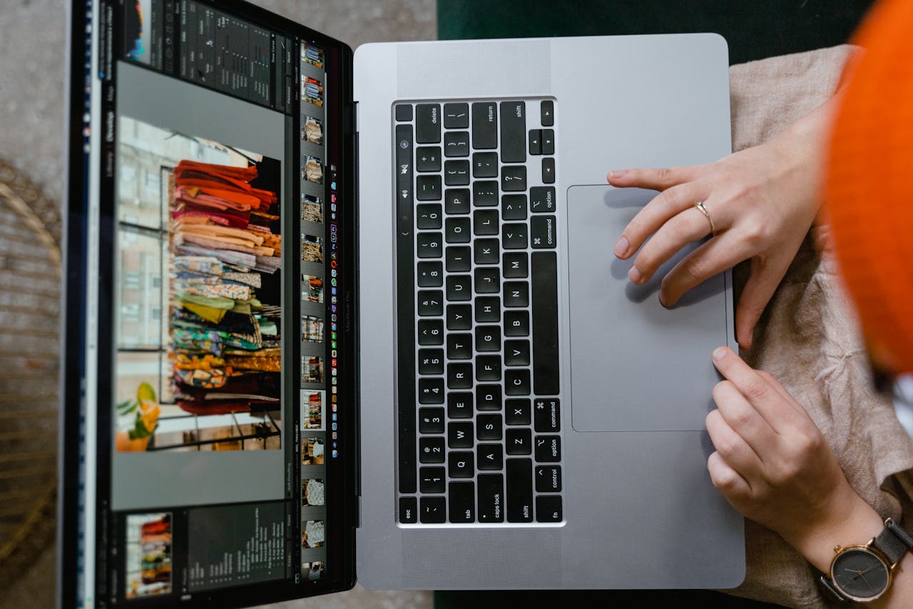 heros-img Top view of hands using a laptop showing online fashion shopping platform, highlighting technology and connectivity.